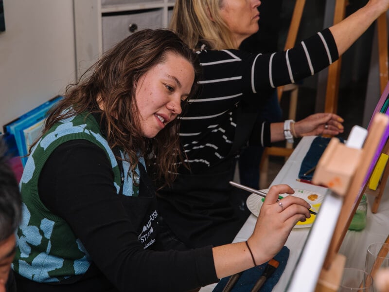 woman smiling at paint and sip class